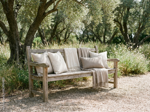 Wooden bench with pillows and blankets in a peaceful outdoor setting