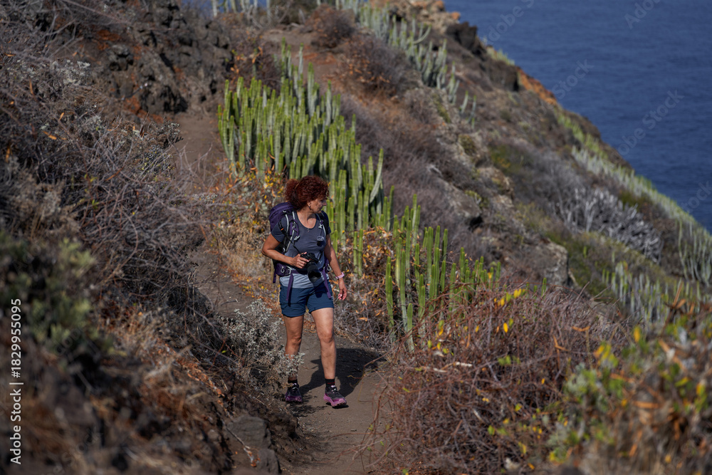 Fototapeta premium Woman photographer hiking Anaga coast