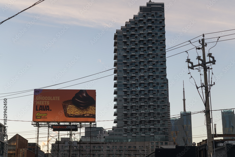 Obraz premium road side billboard with advertising of Reece candy and a silhouetted view of Monde Condominiums (east elevation), Toronto
