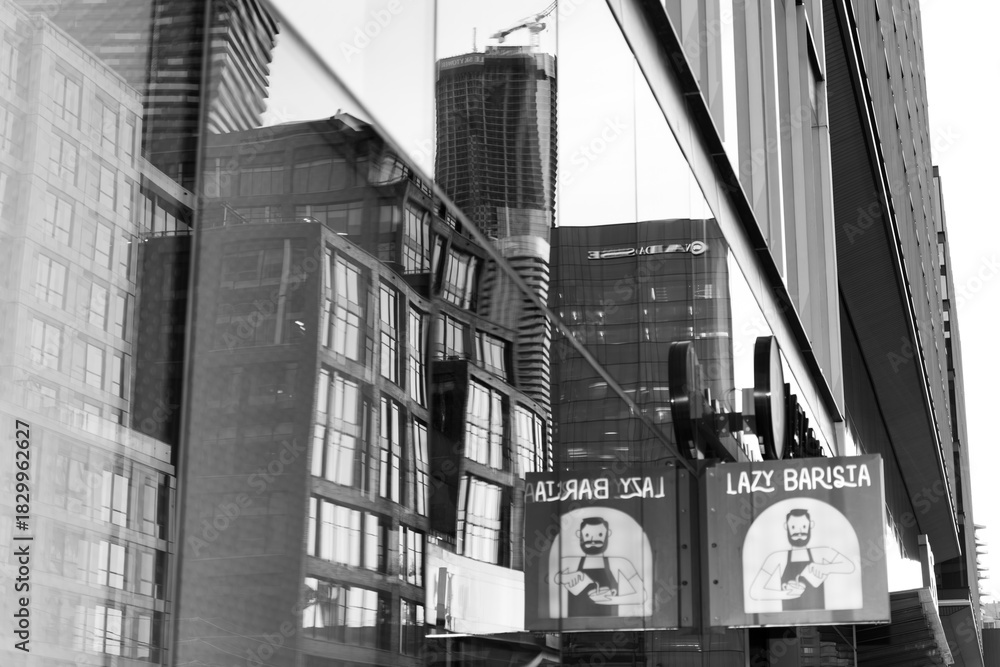 Obraz premium black and white distorted reflection and projecting sign of Lazy Barista, a coffee shop, located at 157 Queens Quay E, Toronto