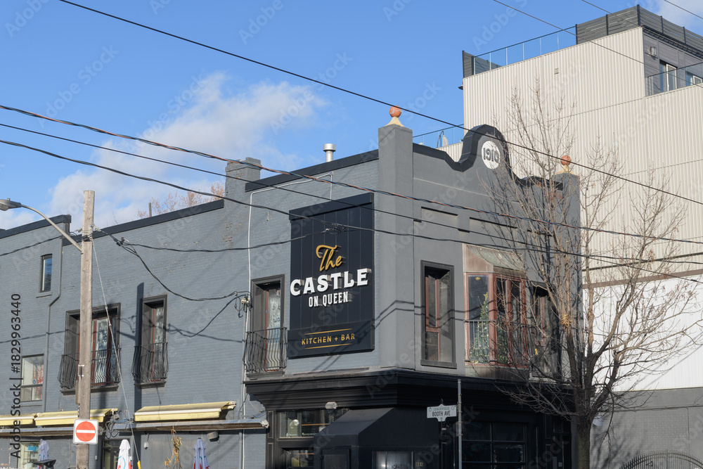 Fototapeta premium exterior building and sign of The Castle On Queen, a restaurant, located at 884 Queen St E, Toronto