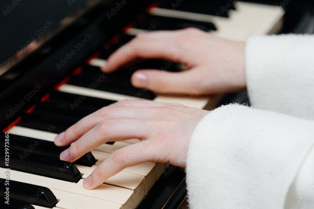 Obraz premium female pianist hands on black and white piano keyboard, close-up view, young woman playing piano, professional musician