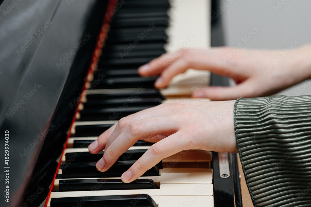 Obraz premium female pianist hands on black and white piano keyboard, close-up view, young woman playing piano, professional musician