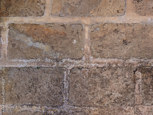 Close-up texture of worn distressed Marés stone slabs on rustic Mallorcan patio floor. Courtyards and patios traditional limestone surface, Mediterranean architecture. Weathering, cracking, age. 