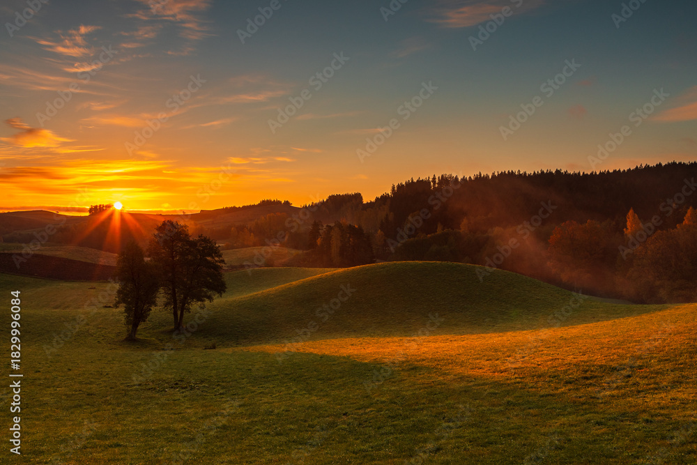 Obraz premium Sunrise Over Rolling Hills in Suwalski Park Krajobrazowy, Poland.