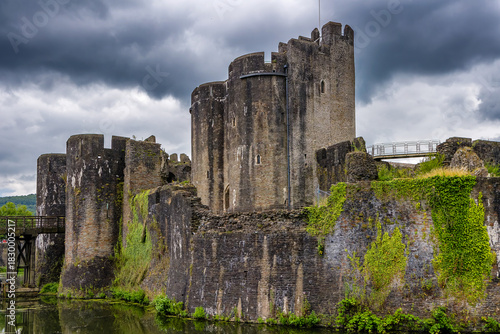 Medieval stone ruins and towers of Caerphilly Castle surrounded by its water moat