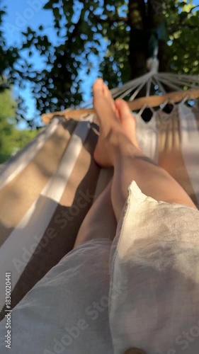 A person relaxes in a hammock outdoors enjoying a calm and peaceful summer day