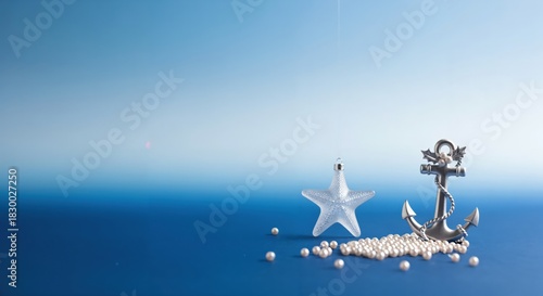 Nautical themed Christmas decoration with silver anchor, clear starfish, and white pearls on a blue background, evoking a serene holiday atmosphere.