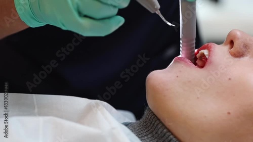 A dentist treats the teeth of a young patient in a dental clinic.