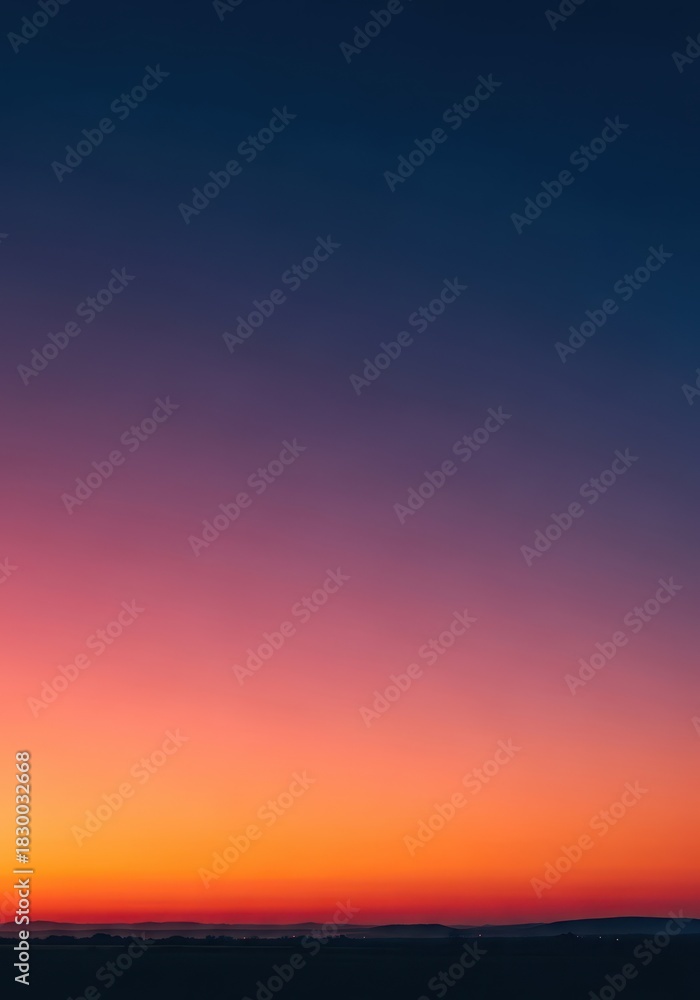 Obraz premium Tranquil evening landscape during golden hour. The expansive sky transitions spectacularly from vibrant orange and pink to deep blue and dark indigo, natural, vibrant, restful