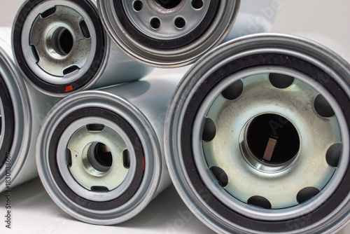 Several white spin-on oil filters arranged horizontally on neutral background, ideal for automotive maintenance catalog or engine-parts ecommerce presentation as clean product display.