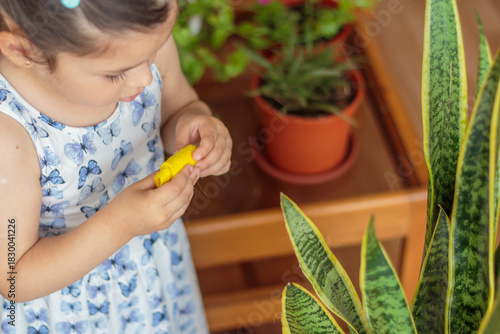 Niña concentrada en cuidar una planta