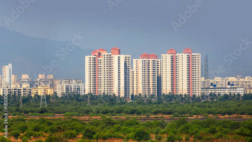 Photography Distant view of new construction of tall apartment home buildings in newly developed Navi Mumbai city, India
