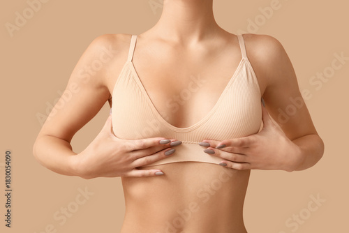 Bild auf Leinwand Young woman in bra on beige background, closeup
