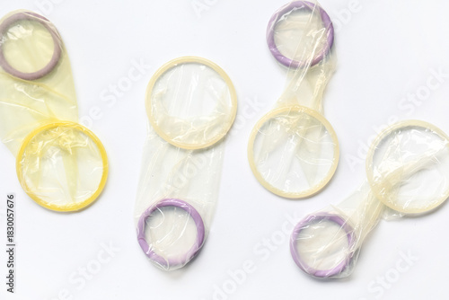 Set of open condoms on whit...