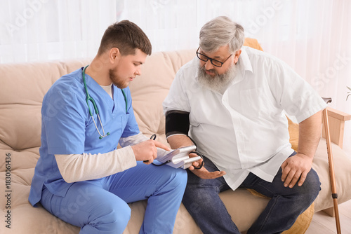 Young caregiver measuring b...