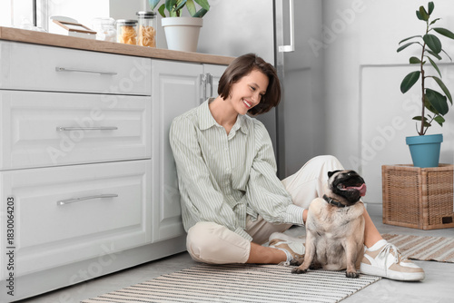 Young woman with cute pug d...