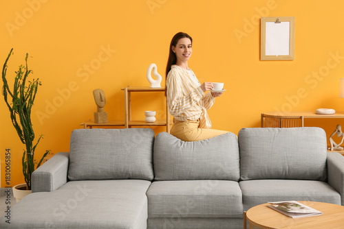 Young woman holding cup and...