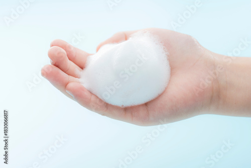 子どもの手に広がるきめ細かな泡を捉えた清潔感あふれるヘルスケアイメージ