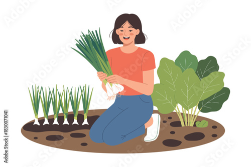 A woman harvesting green onions in her garden with a smile on her face