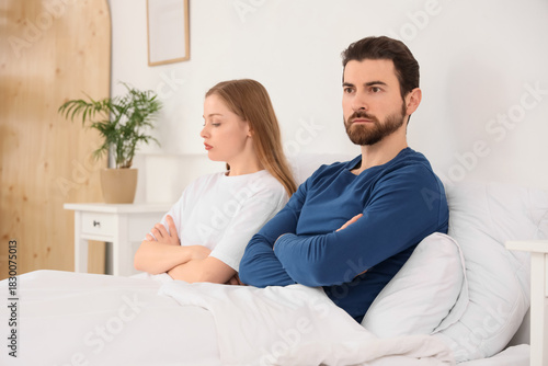 Offended young couple after quarrel lying in bedroom
