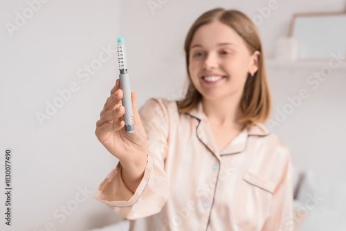 Young woman with syringe of...