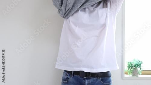 セーターを脱ぐ男性（日本人、顔無し、30代）