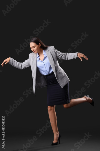 Photos Businesswoman in pose of marionette on dark background