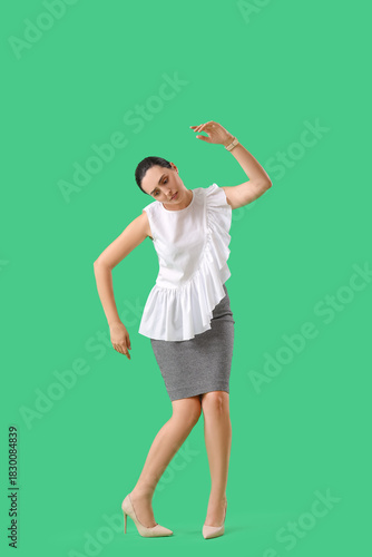 Bilde på lerret Businesswoman in pose of marionette on green background