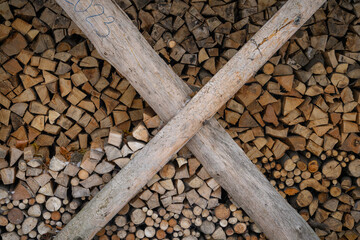 Fototapete Brennholz Textur Chopped firewood stored outside behind boards in the shape of a cross.   © lapis2380