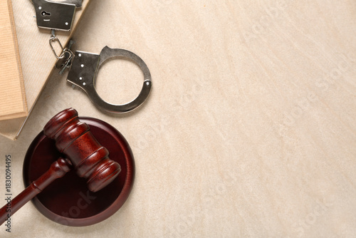 Foto Judge's gavel with handcuffs and books on light grunge background