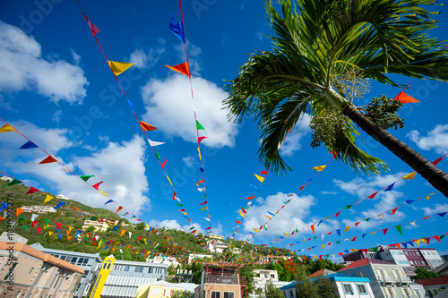 Carnival bunting flags strewn from building and palm trees across a plaza in Road Town, Tortola in the Caribbean