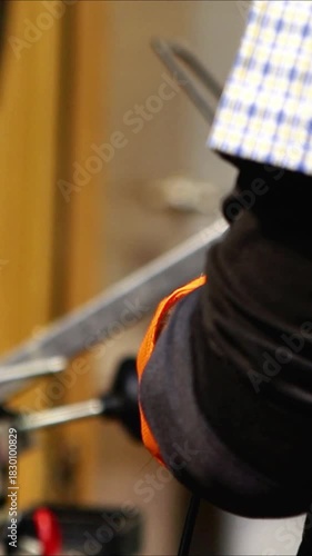 Bicycle mechanic cutting cable housing in workshop