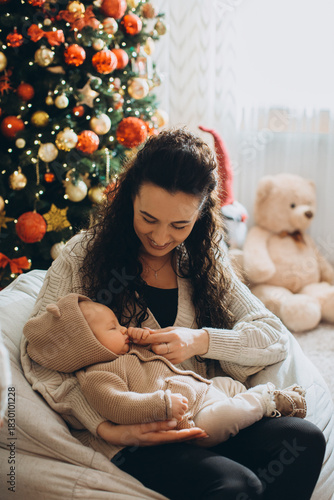 Mother holding newborn baby celebrating first christmas