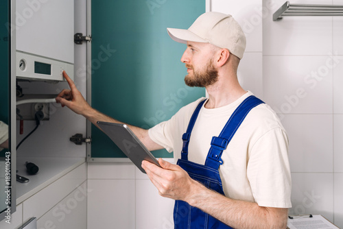 Repairman conducting maintenance on gas boiler in modern bathroom setting