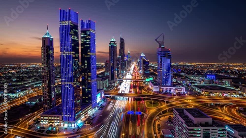 Wallpaper Mural Tall skyscrapers adorned with vibrant lights stand proudly against a twilight sky, illuminating the bustling city below. The busy highways weave through the urban landscape, showca Torontodigital.ca
