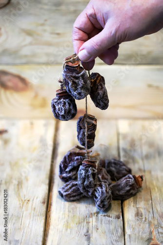 Close-up of hands holding dried persimmons, or hoshigaki.
