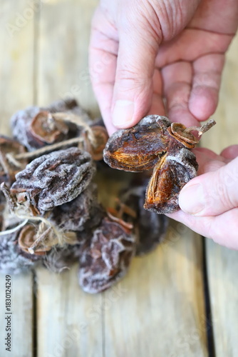 Close-up of hands holding dried persimmons, or hoshigaki.