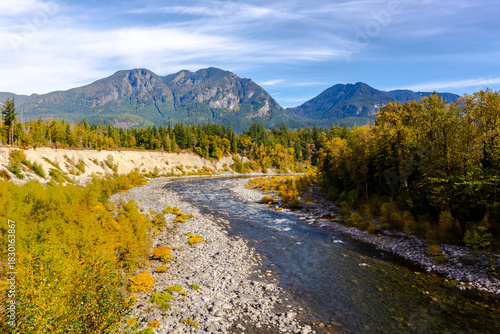Mountain range towering over an autumn river landscape. Skykomish River in Washington