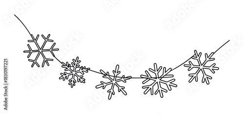 Delicate string of black outline snowflakes garland hung on a thin line for winter holiday decoration and festive celebration