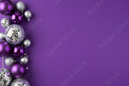 Arrangement of red Christmas ornaments and purple and silver disco balls creates a festive, modern holiday scene suitable for Christmas and New Year greetings and seasonal decor.