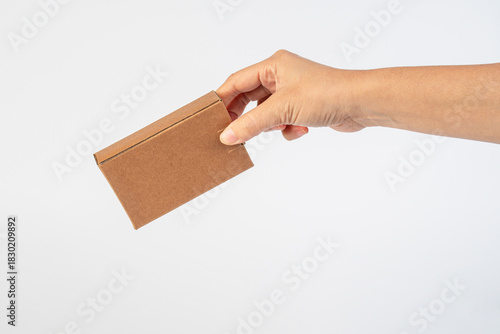 Small brown cardboard box in hand on a white background.