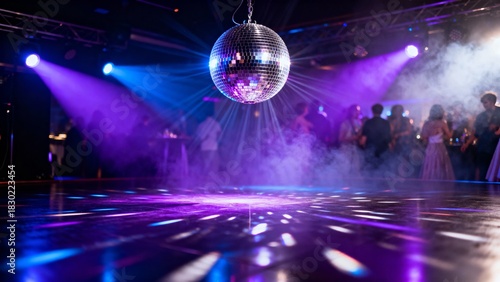 Disco ball hanging over dance floor with colorful lights and crowd - Concept of New Year and Christmas  