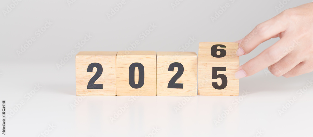 Fototapeta premium 2025 change to 2026 year block on table. goal, Resolution, strategy, plan, start, budget, mission, action, motivation and New Year concepts