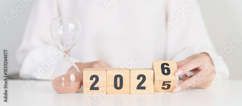 2025 end year to Happy New Year 2026 with hourglass on table. Resolution, time, plan, goal, motivation, reboot, countdown and New Year holiday concepts