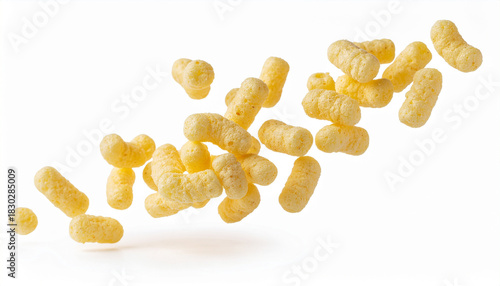 A group of yellow, crunchy corn puff snacks is suspended in mid-air, with a clean white background emphasizing their light and airy texture.