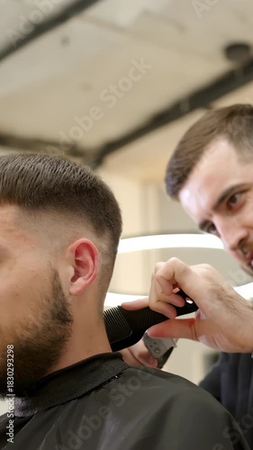 Professional barber giving haircut with clipper. Clip