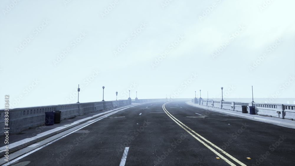 Fototapeta premium A solitary road disappears into dense fog, leading through a calm cityscape. Streetlamps line the path, creating a serene atmosphere in the early morning light.