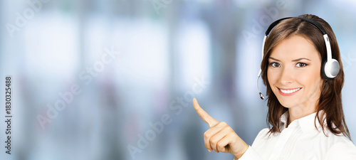 Image - happy smile customer support phone operator wear headset pointing advertise. Representative call center callcenter service. Businesswoman woman on blurred office background. Wide banner