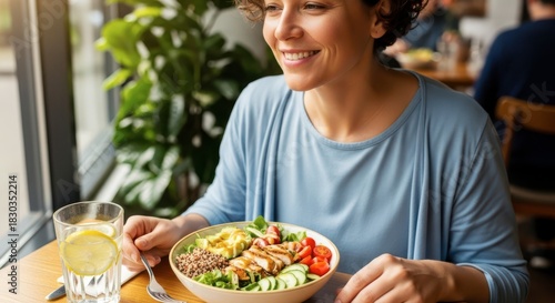 Smiling woman enjoying healthy grain bowl lunch indoors